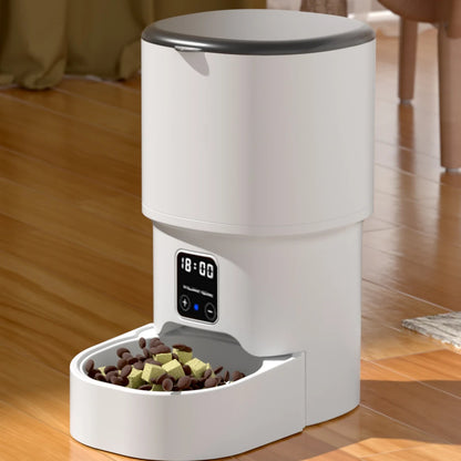 White 4L WiFi automatic cat and dog feeder dispensing kibble into bowl on wood floor.